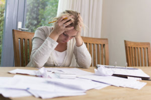 unexpected income loss woman stressed about paying bills