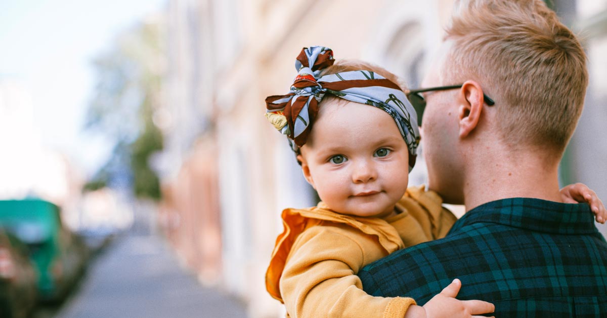 father carrying a baby receiving a child support modification from family law attorney