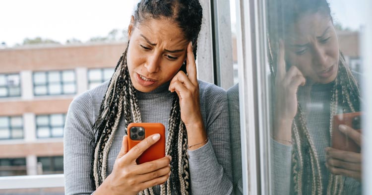 woman looking at social media on her phone amid a divorce